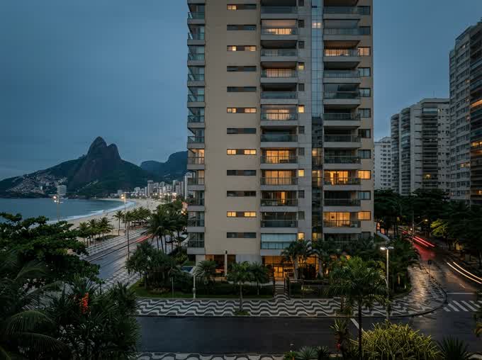 Torre residencial moderna de vidro vista da rua ao anoitecer